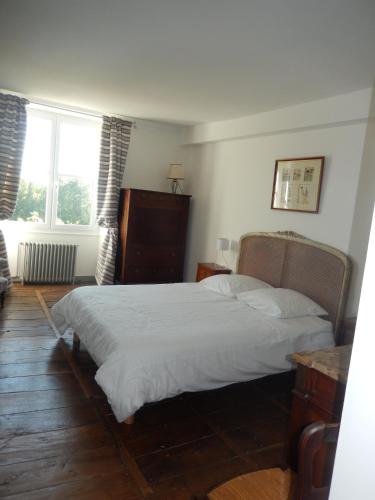 une chambre avec un lit et deux fenêtres dans l'établissement Domaine de Puyrousse, à Ribérac