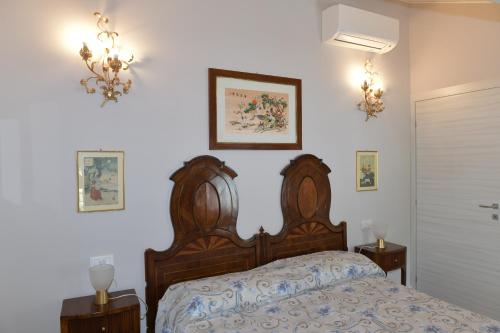 een slaapkamer met een bed met een houten hoofdeinde bij Civico 43 in Carpenedolo