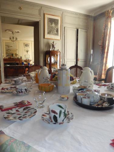 une table avec des assiettes et de la vaisselle en haut dans l'établissement Domaine de Puyrousse, à Ribérac
