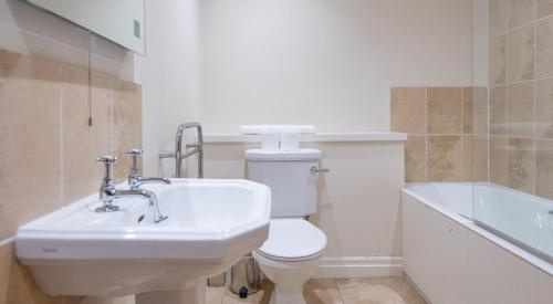 a bathroom with a sink and a toilet and a tub at Newlands in Rusland