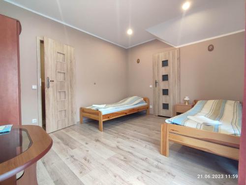 a small room with two beds and a table at Agroturystyka Robinia in Bałtów