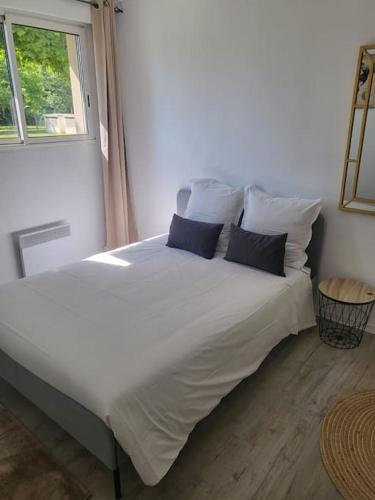 - un lit blanc avec deux oreillers et une fenêtre dans l'établissement Appartement proche Disney Paris, à Montévrain