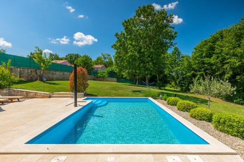una piscina en un patio con patio y árboles en Villa Nona Nina en Poreč