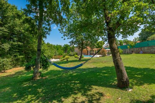 a blue hammock hanging between two trees in a yard at Villa Nona Nina in Poreč