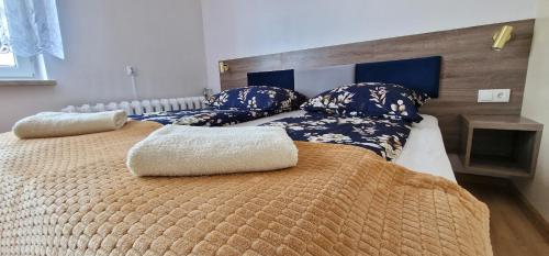 a bedroom with two beds with blue and white pillows at Pokoje u Agaty in Solec-Zdrój