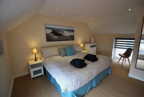 a bedroom with a bed with two hats on it at Net Loft- homely accomodation in East Neuk in Anstruther