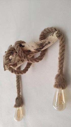 a rope hanging on a wall with two lights at Il Racconto Terra in Nocera Umbra