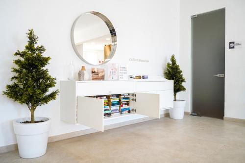 a white vanity with a mirror and a potted tree at Vitor's Plaza in Portimão