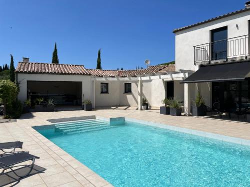 une piscine devant une maison dans l'établissement Villa ARTOS - piscine - 300 m2, à Carcassonne