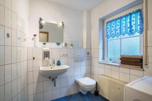 baño con lavabo y aseo y ventana en Ferienwohnung Schläfer, en Kappel-Grafenhausen