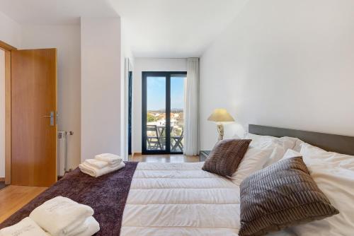 a bedroom with a large bed with towels on it at Sublime Mundo Apartamento in Apúlia