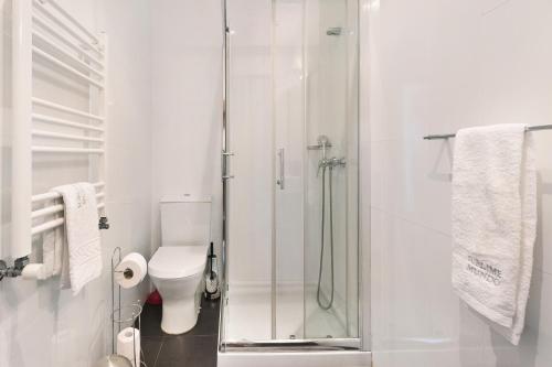 a white bathroom with a shower and a toilet at Sublime Mundo Apartamento in Apúlia