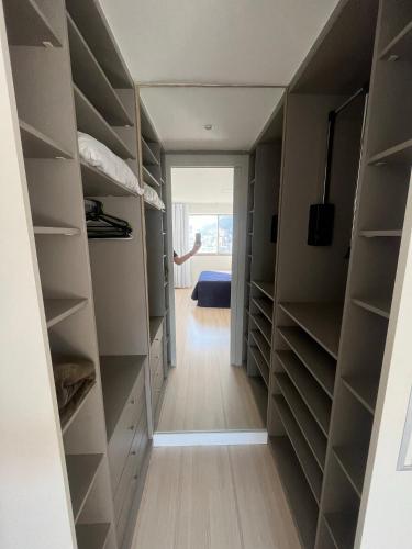 a walk in closet with a bed in the background at Apartamento com Vista Imperdível in Rio de Janeiro