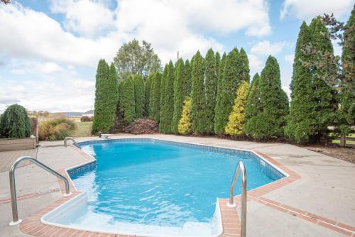 einen Pool in einem Garten mit Bäumen in der Unterkunft Cozy Cow in Gettysburg