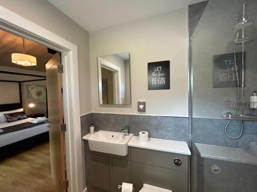 a bathroom with a sink and a shower at Breckland Lodge 3 with Hot Tub in Belladrum