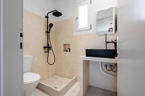 a bathroom with a sink and a toilet and a mirror at Celestial Seaview Apartments-Portara in Naxos Chora