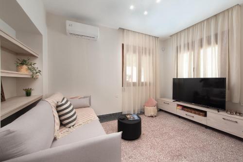 sala de estar con sofá y TV de pantalla plana en My Pixida Apartments, en Rodas