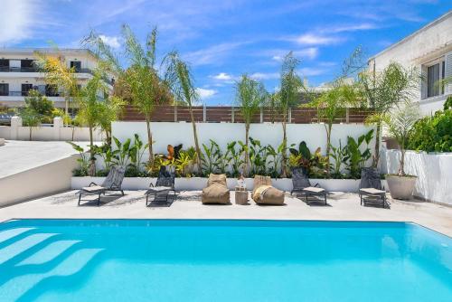 a swimming pool with lounge chairs and a fence at My Pixida Apartments in Rhodes Town