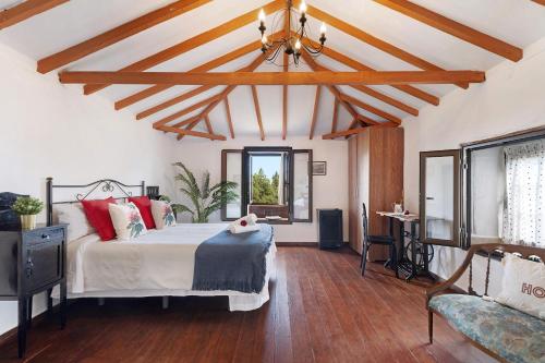 una camera con un letto in una stanza con pavimenti in legno di Casa Rosalía a Icod de los Vinos