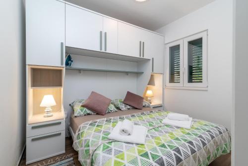 een slaapkamer met een bed met twee handdoeken erop bij Apartments Jurica in Trogir