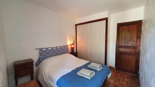 a bedroom with a bed with two towels on it at La Magnanerie in Portes-en-Valdaine