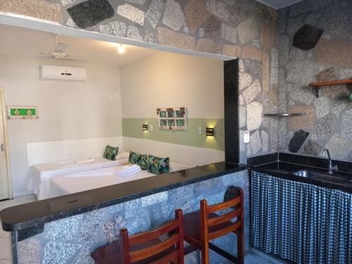 a bar with a sink and a bed in a room at Pousada Mar E Mata in Guarapari