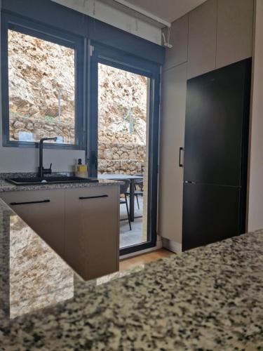 a kitchen with a sink and a table and a window at Casa Buena Vista con piscina y ascensor in Cullera