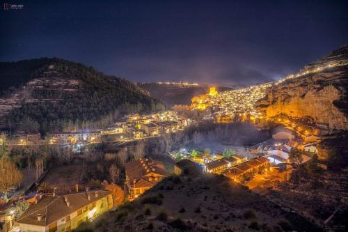 a city at night with lights on a mountain at Casa Villar in Alcalá del Júcar