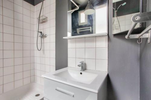 a white bathroom with a sink and a shower at Montmartre Superbe Studio Paris in Paris
