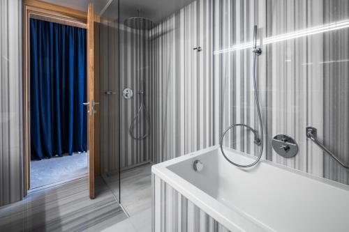 een badkamer met een douche en een wit bad bij Met Boutique Hotel in Zagreb