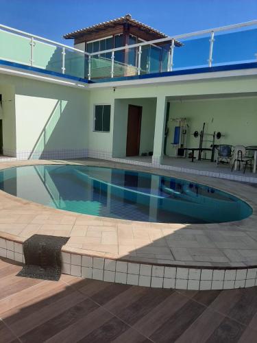 a swimming pool in front of a house at Linda casa pertinho da Lagoa in Iguaba Grande