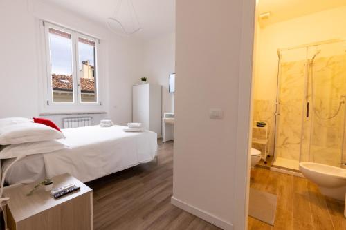 um quarto branco com uma cama e uma casa de banho em Cavour Florence Apartment em Florença