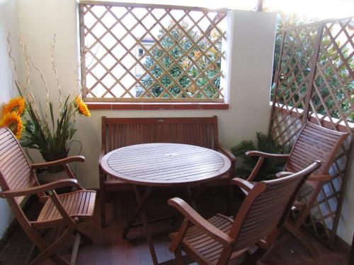 a patio with a table and chairs and a window at Apt Versilia in Viareggio