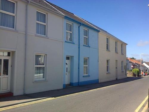 a row of white houses on a street at A Family Cottage in Tenby in Tenby