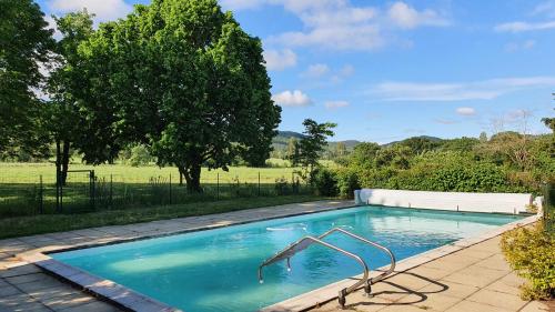 a swimming pool in the middle of a field at La Magnanerie in Portes-en-Valdaine