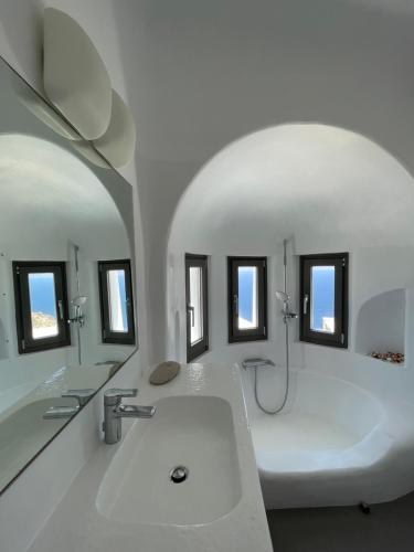 Baño blanco con bañera y lavamanos en Villa Faros, en Fanari