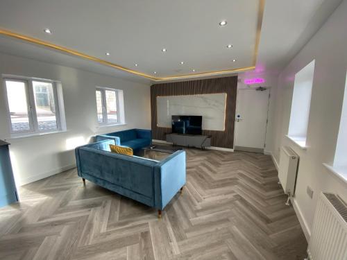 a living room with a blue couch and a television at Walter Road Holiday Home Swansea - 4 bedrooms in Swansea