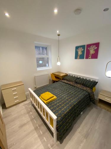 Walter Road Holiday Home Swansea - 4 bedrooms في سوانسي: غرفة نوم عليها سرير وفوط صفراء