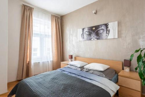 a bedroom with a bed with a picture on the wall at 2 bedrooms apt near Wenceslas sq in Prague