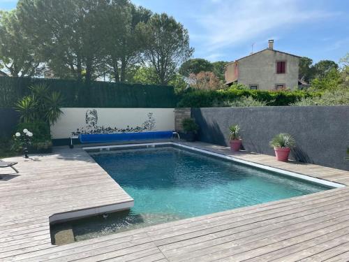 - une piscine dans un jardin avec une terrasse en bois dans l'établissement Villa piscine, spa & pétanque à Uzès centre !, à Uzès