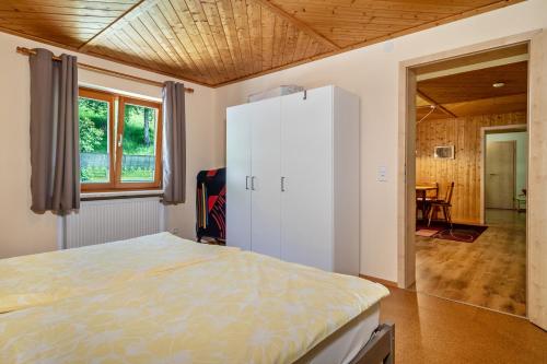 1 dormitorio con 1 cama y nevera blanca en Balzerberg en Weiler-Simmerberg