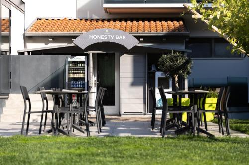 a group of tables and chairs with an umbrella at Aktivhotel Santalucia in Nago-Torbole