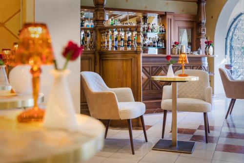 a restaurant with a bar with chairs and a table at Parkhotel Delta, Wellbeing Resort in Ascona