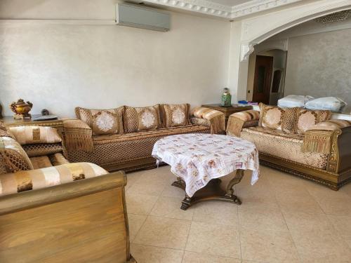 a living room with couches and a table at Vaste appartement au centre de Tetouan in Tetouan
