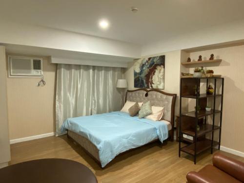a bedroom with a bed with blue sheets and a window at Feels Like Home Condos Abreeza Place Tower 1 & 2 in Davao City