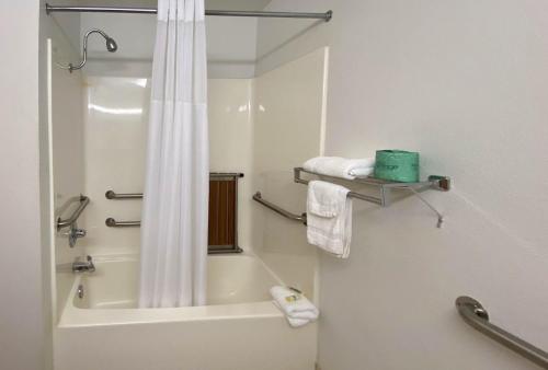 ein Bad mit einer Badewanne und einer Dusche mit einem Duschvorhang in der Unterkunft Studio 6 McAlester OK South in McAlester