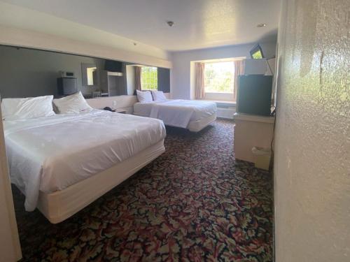 um quarto de hotel com duas camas e uma janela em Studio 6 McAlester OK South em McAlester