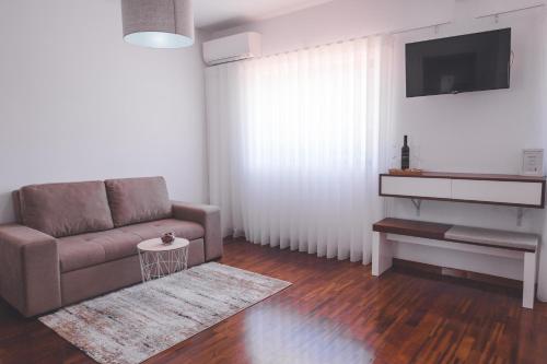 a living room with a couch and a tv at Quinta da Portela Douro in Armamar