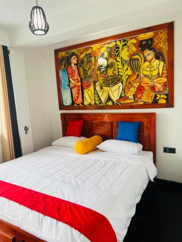 a bedroom with a bed with a painting on the wall at SKYRAH REACH in Kandy