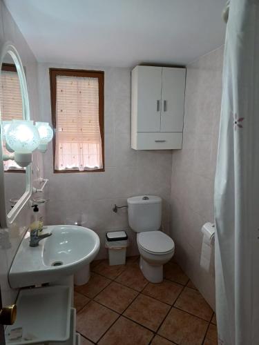 a bathroom with a white toilet and a sink at Cortijo las lagunillas in La Puerta de Segura